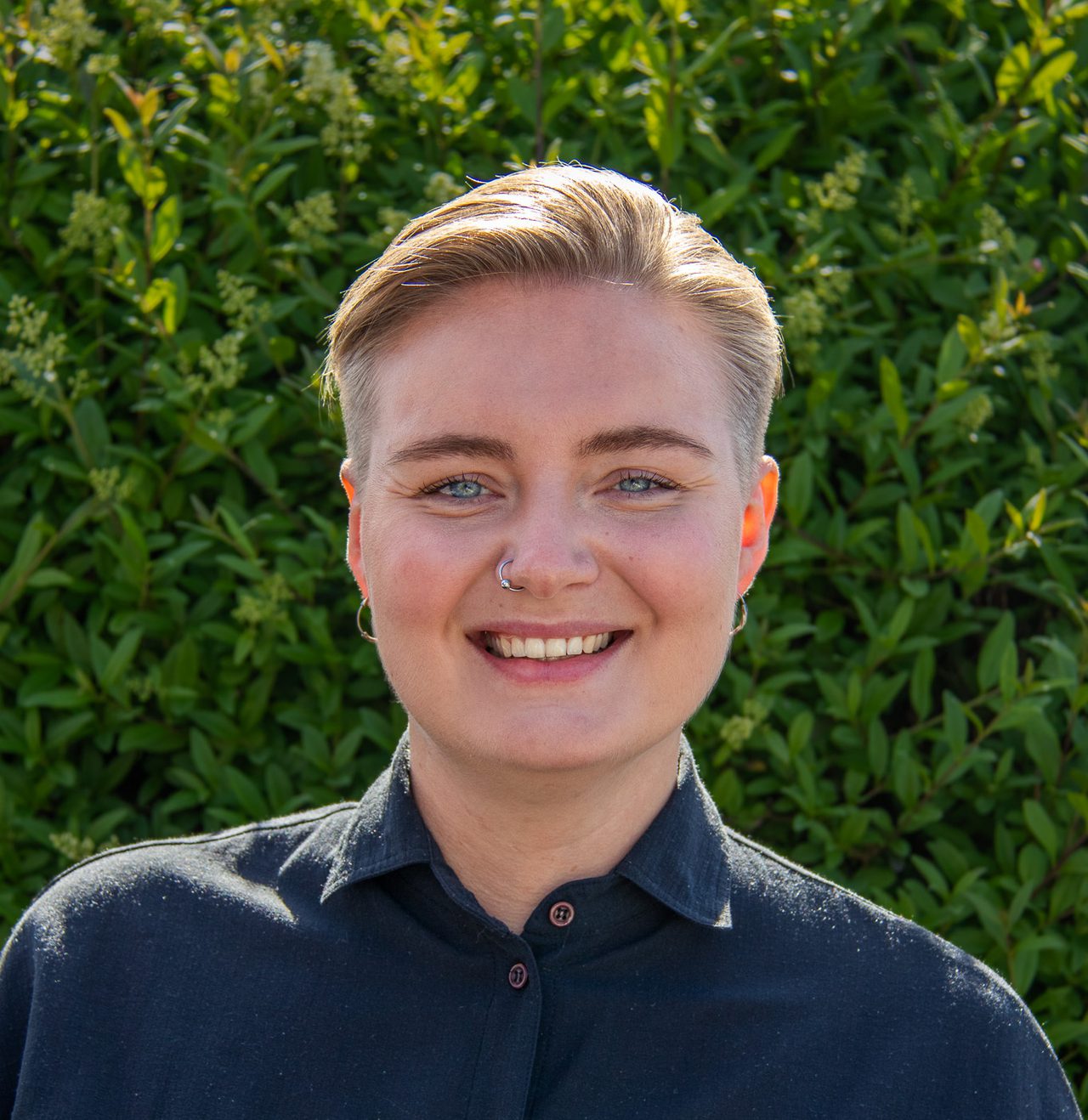Maren smiler bredt iført en kortermet svart skjorte. Hun har kort, mørkeblondt hår.