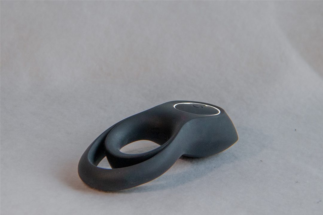 leketøyet er formet som et åttetall, hvor den ene enden er en knapp for å styre vibrasjoner, og den andre delen er en ring som tres på penis.